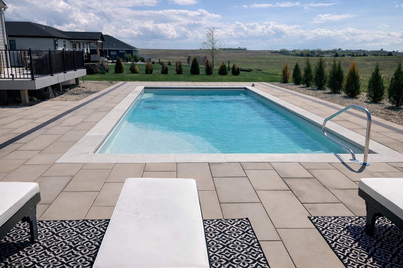 Custom pool with paver surround and lounge chairs — Hovey pool builder Siouxland