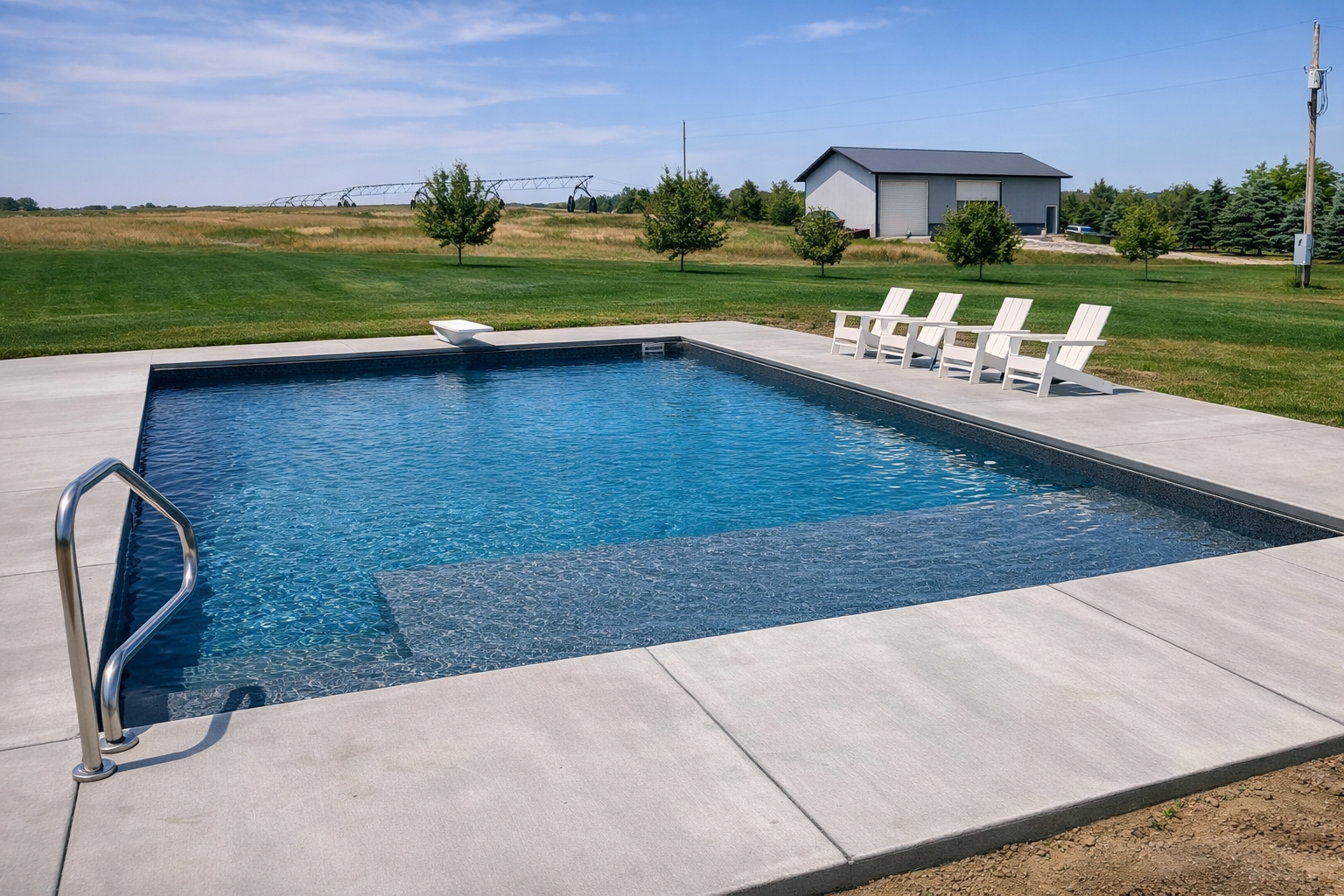 Dark liner inground pool with Adirondack chairs — custom pool builder South Sioux City