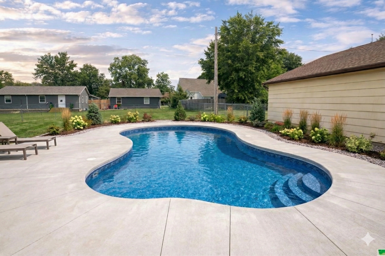 Freeform pool with water features and mature landscaping — custom pool Siouxland